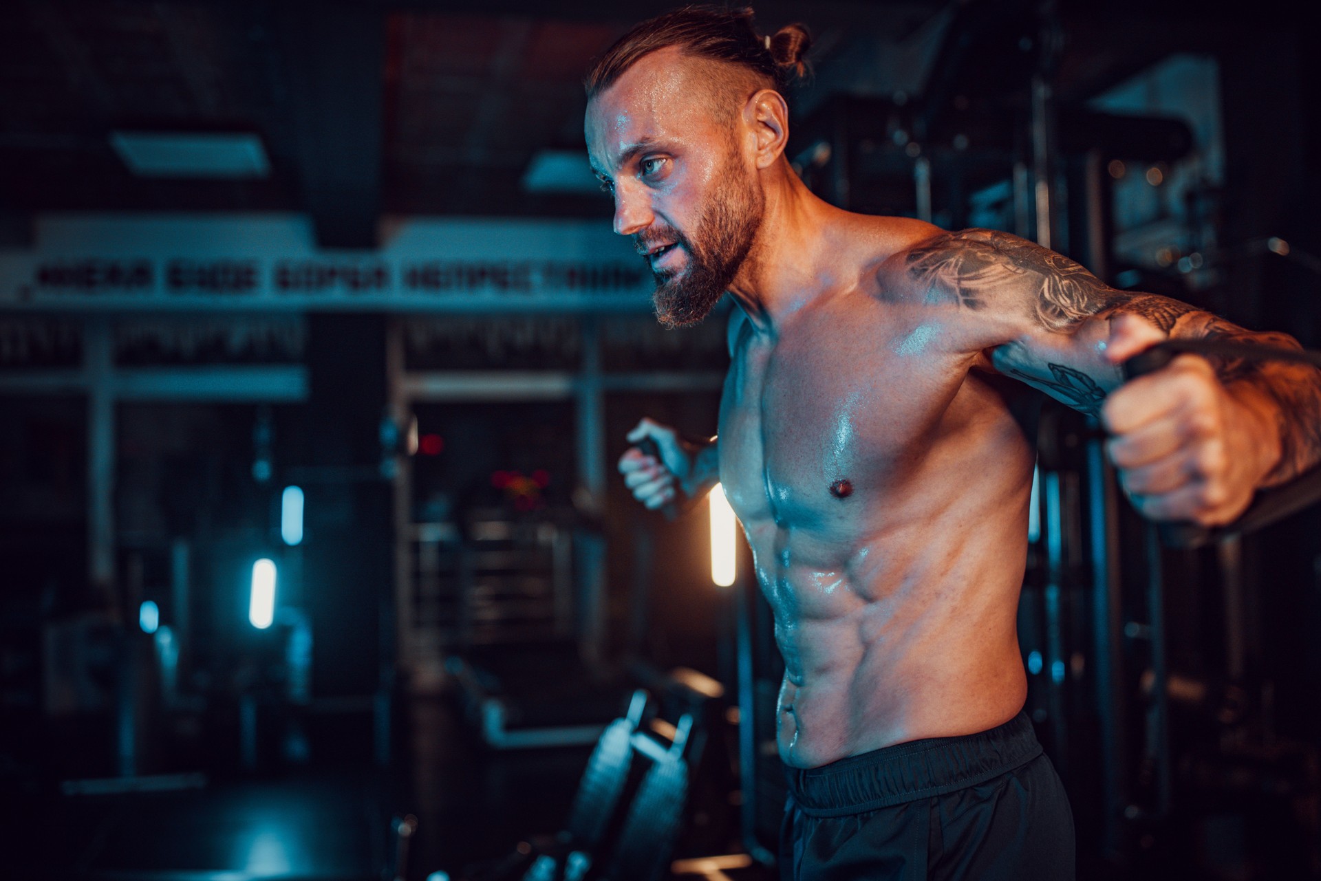 Focused man exercising with cable machine in gym